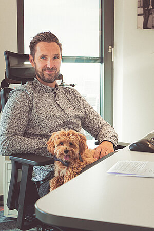 CEO Frank Niemann mit Huendin Chewy am Schreibtisch