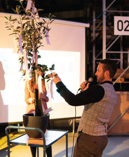 Frank Niemann accepts an apple tree with wishes for the future as a housewarming gift from Cybertrading employees