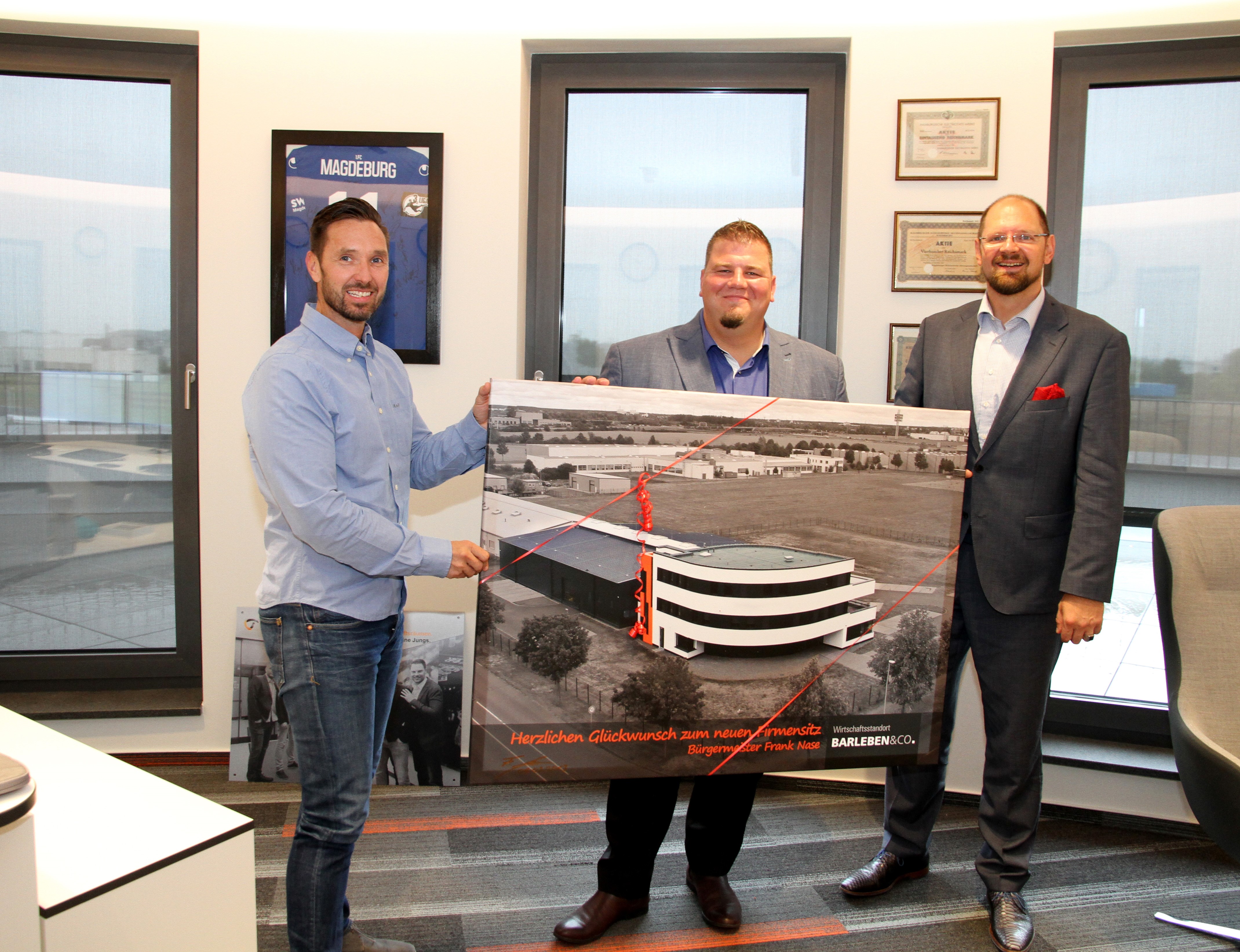 Frank Nase (Mayor of Barleben) & Martin Stichnoth (District Administrator of the Börde district) present Frank Niemann with an aerial photo of the company building