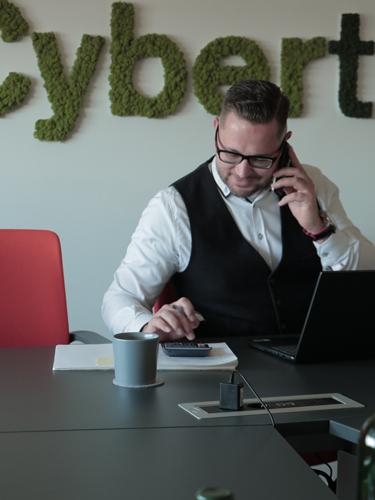 man sitting at desk and talking on phone