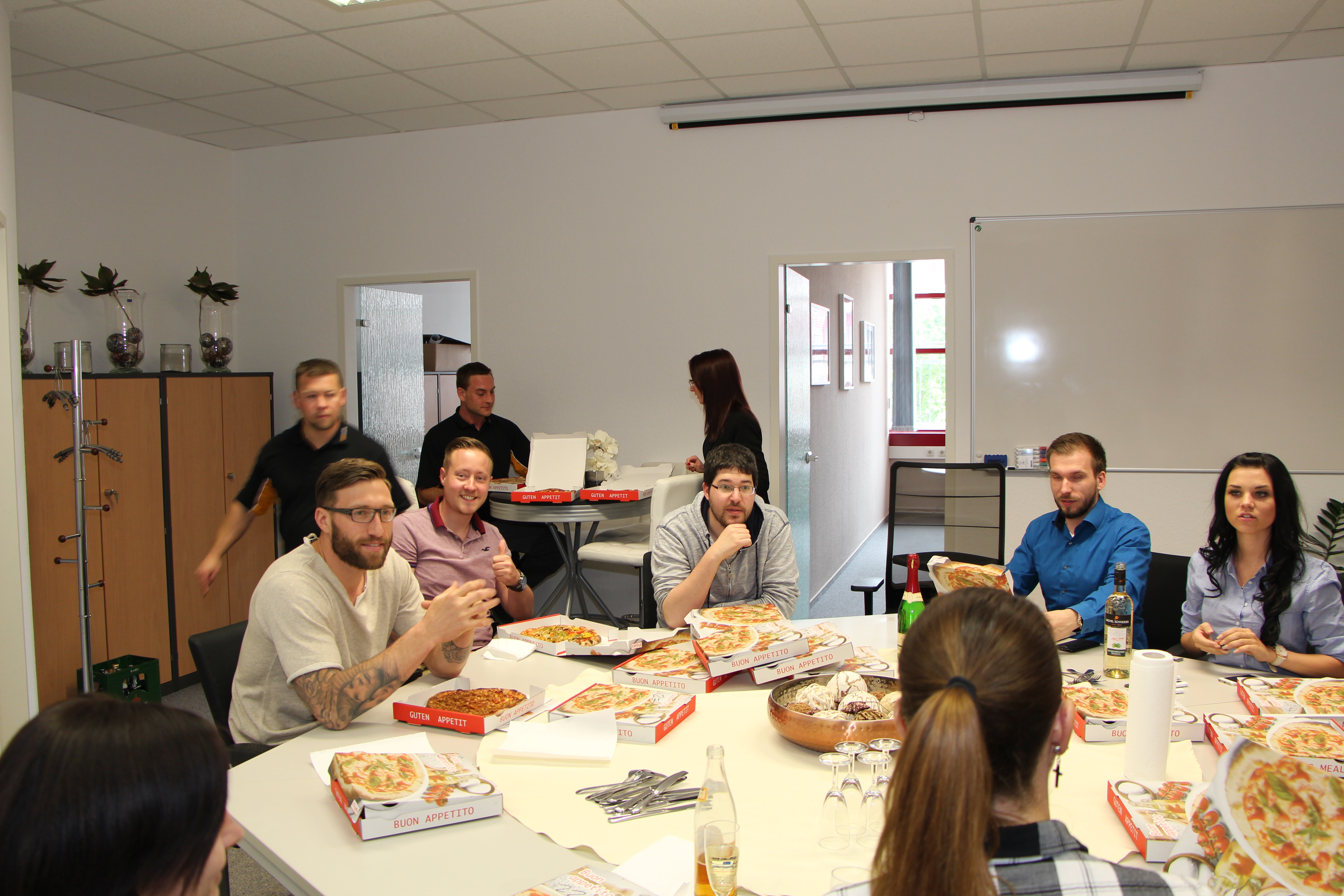 Meetingraum mit Menschen, die am Tisch sitzen und Mittag essen