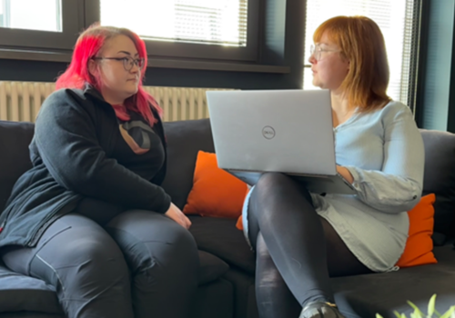 Two women sitting on a sofa and talk