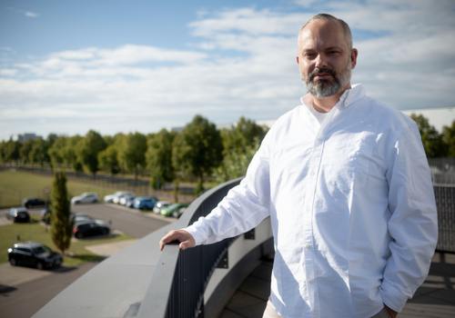 A man stands on a balcony