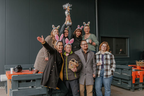 eine Personengrupe, die einen Pokal hochhält und Hasenohren trägt