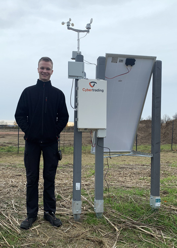 Azubi neben Wetterstation