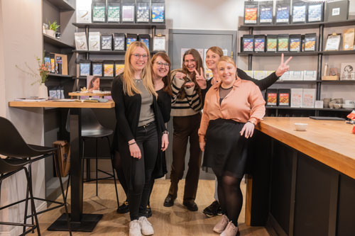 Fünf Frauen stehen in einem Café