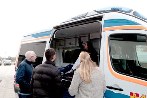 Volunteer explains the interior of the Wünschewagen to the CEO and Head of Marketing of Cybertrading