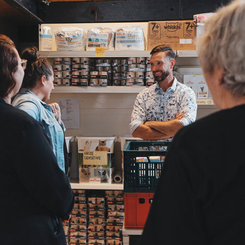 Volunteers showing CEO of Cybertrading the storage room with all the food